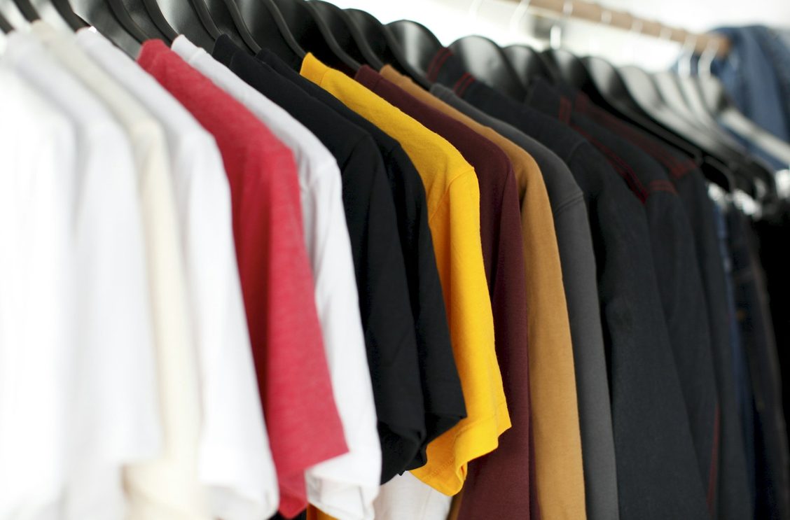 Shirts in white, red, yellow, brown and black hanging neatly on a rail